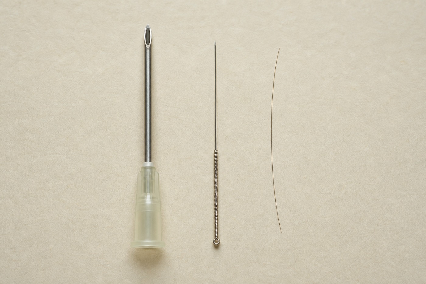 An acupuncture needle, a blood-draw needle and a human hair side by side